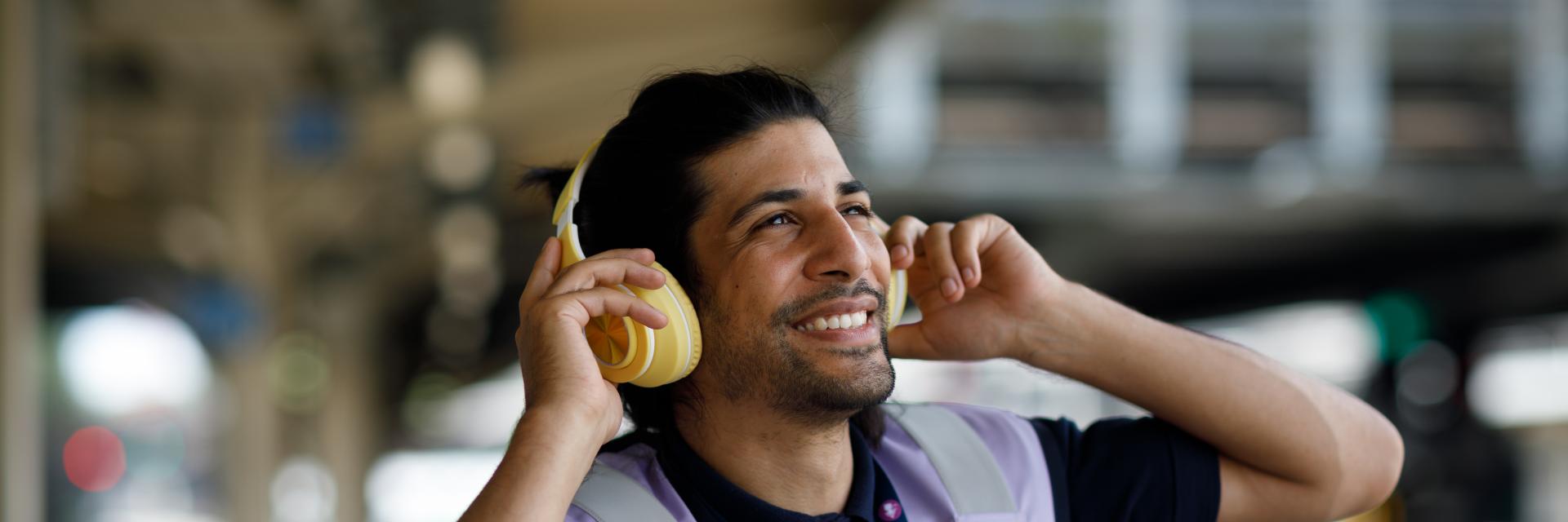 rail worker with headphones on, smiling